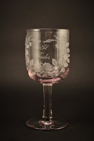 Gammelt erindrings glas fra Holmegaard glasværk med 
fine graveret blomster dekorationer og skrift "Til Fader"
H:16,5cm. Dia:7,5cm.