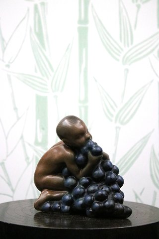Kai Nielsen glazed ceramic figurine of a boy eating grapes...