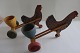 "Chiken pushcart "
2  old/antique chickens, each with a pushcart 
with a egg cup. 
They are made of wood handmade
There are stamps, but we cannot read them, sorry
Both are in a good condition and they work fine