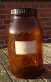 Stor og velholdt apotekerflaske 5 liter i 
mørkebrunt glas. På mærkat "322722" og "Pulvis 
Dentifricius Camphoratus".