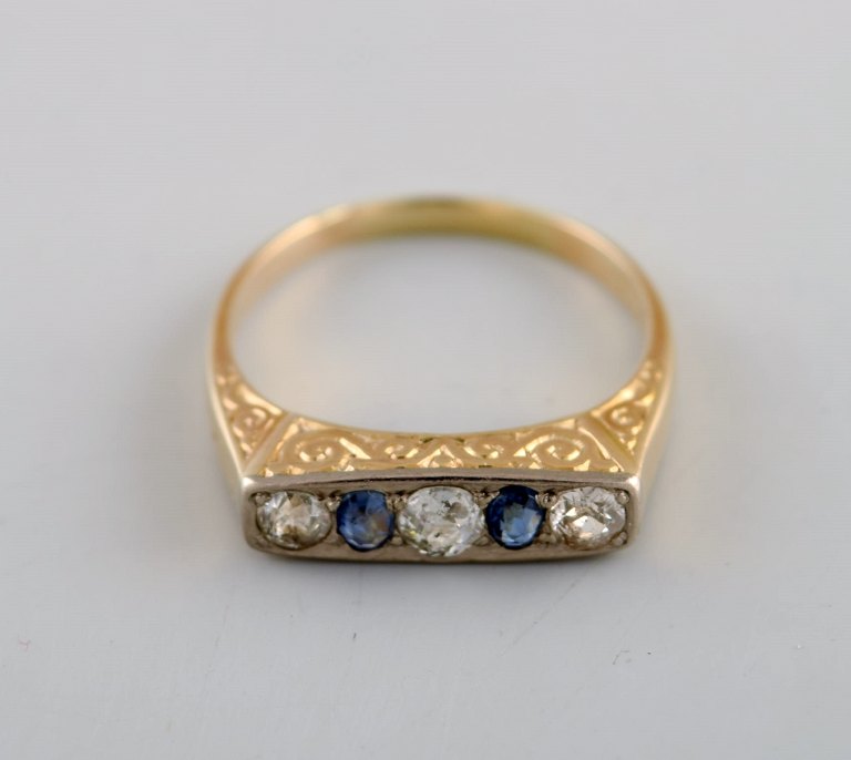 Scandinavian jeweler. 14 carat art deco gold ring adorned with brilliants and sapphires. Mid 20th century.
