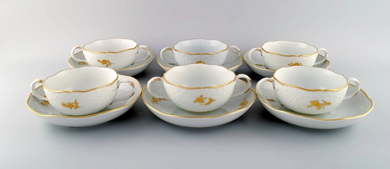Six Meissen boullion cups with saucers in porcelain with flowers and foliage in relief and gold decoration. 20th century.