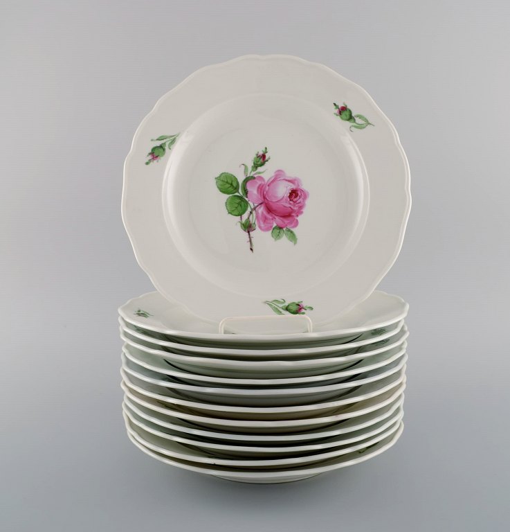 12 antikke Meissen middagstallerkener i håndmalet porcelæn med lyserøde roser. 
Tidligt 1900-tallet.
