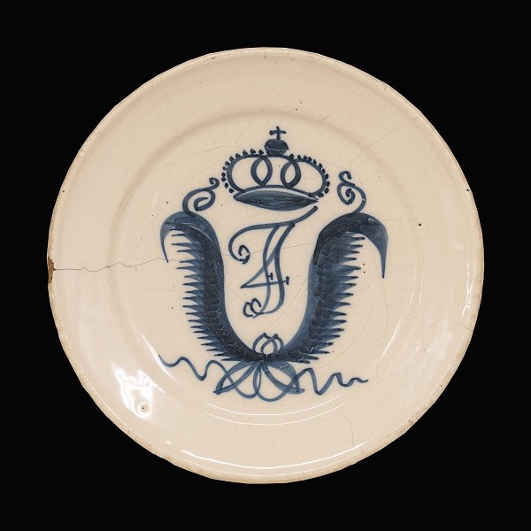 Tidlig St. Kongensgade tallerken i fajance. Prydet med Frederik IVs kronedes monogram. Fremstillet ca. år 1730. D: 22,5cm