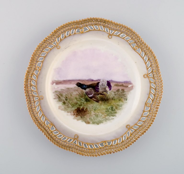 Tidlig og sjælden Royal Copenhagen Fauna Danica tallerken i håndmalet porcelæn med jagtmotiv og gulddekoration. 1800-tallet.