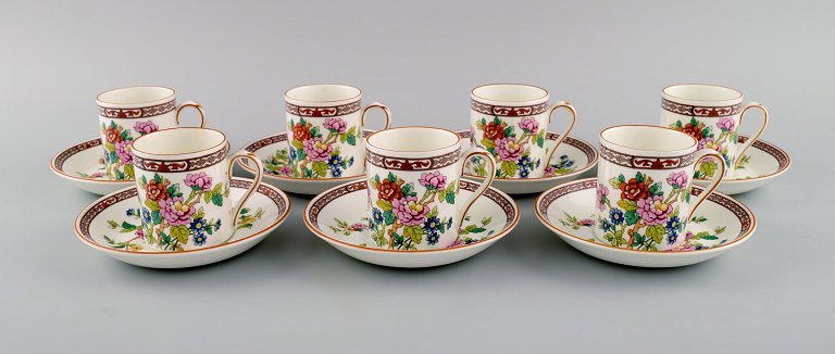Coalport, England. Seven Flower of Tibet chocolate cups with saucers decorated with flowers and gold edge. Mid-20th century.