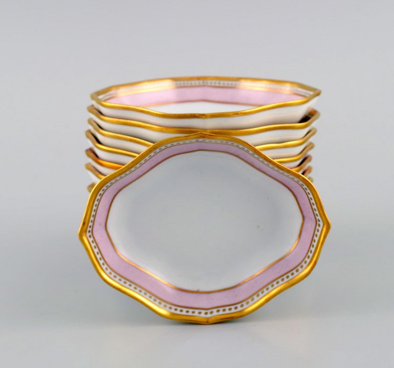 Kaiser, Tyskland. 11 asietter i porcelæn med håndmalet lyserød og guldekoration. 
Dateret 1978.
