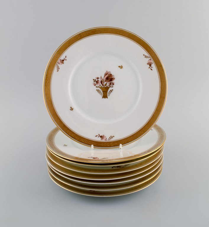 Otte Royal Copenhagen Guldkurv tallerkener i porcelæn med blomster og gulddekoration. Modelnummer 595/10520.