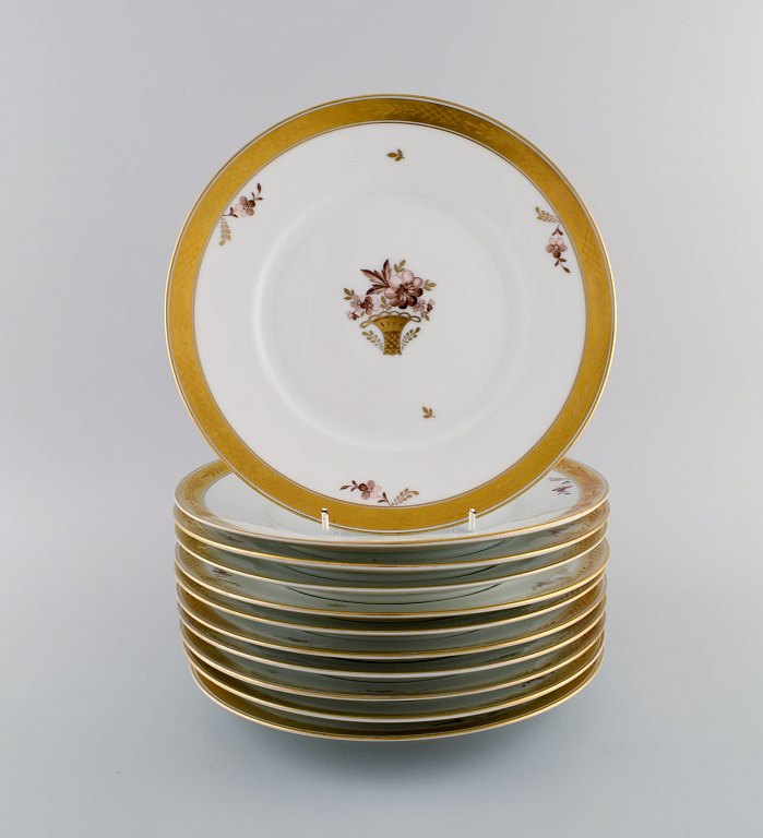 11 Royal Copenhagen Golden Basket porcelain dinner plates with flowers and gold decoration. Model number 595/10519. Early 20th century.