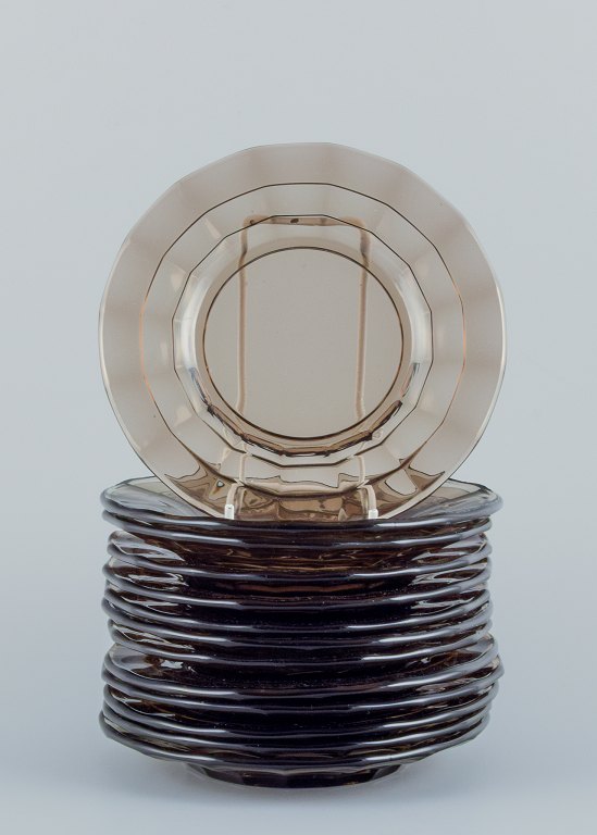 Simon Gate (1883-1945) for Orrefors/Sandvik, Sverige.
Et sæt på tretten små Art Deco tallerkner i røgfarvet presset glas.