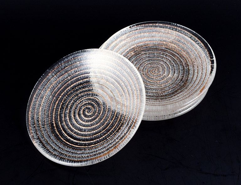 Murano, Italy, a set of four small plates in clear glass with spiral-shaped gold decoration.