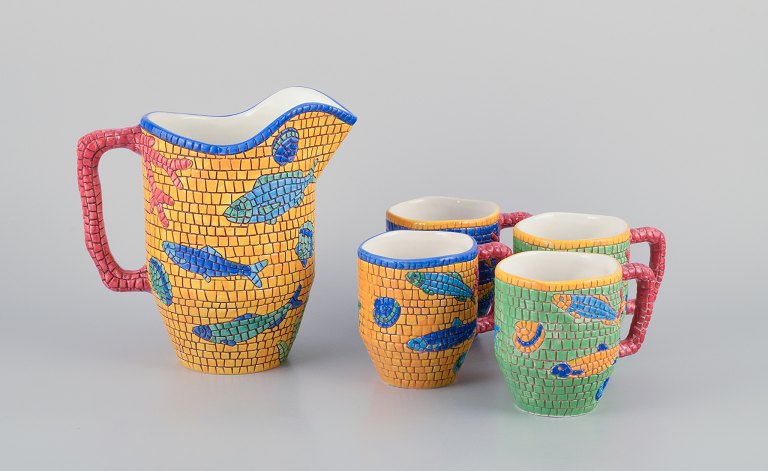 Vietri, Italy. Set of four large mugs and a large pitcher in ceramic. Decorated with fish and sea motifs in a mosaic-like pattern.