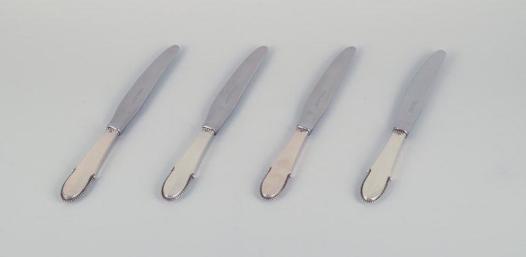 Georg Jensen, a set of four Beaded dinner knives with short handles in 830 silver with stainless steel blades.