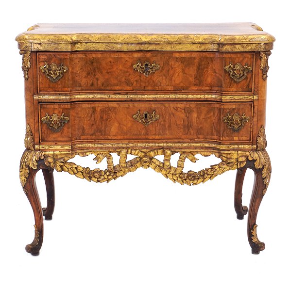 Walnut veneered and partly gilt commode made by the manufacture Köster, Altona, 
Northgermany, circa 1770. H: 78cm. Top: 87x43cm