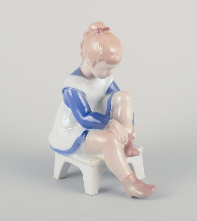 Bing & Grøndahl porcelain figurine, sitting girl tying a shoelace.