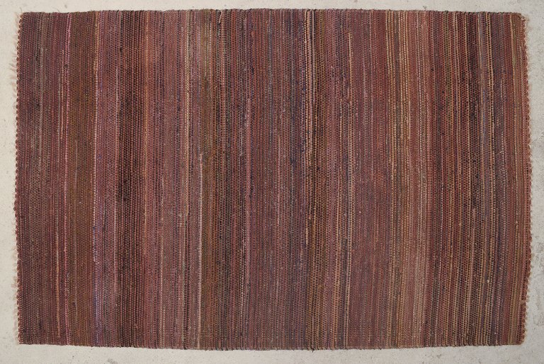 Scandinavian textile designer.
Hand-knotted kilim rug in dark shades.