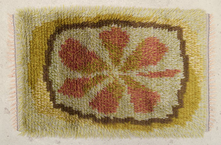 Skandinavisk tekstildesigner.
Ryatæppe af bomuld.
Moviv af blad i efterårsfarver.